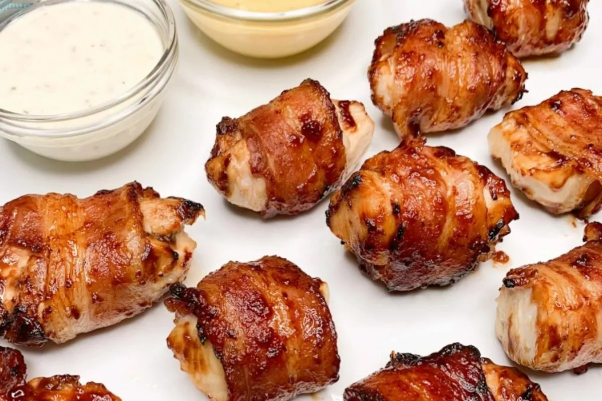 plate of chicken bites wrapped in bacon with bbq sauce.