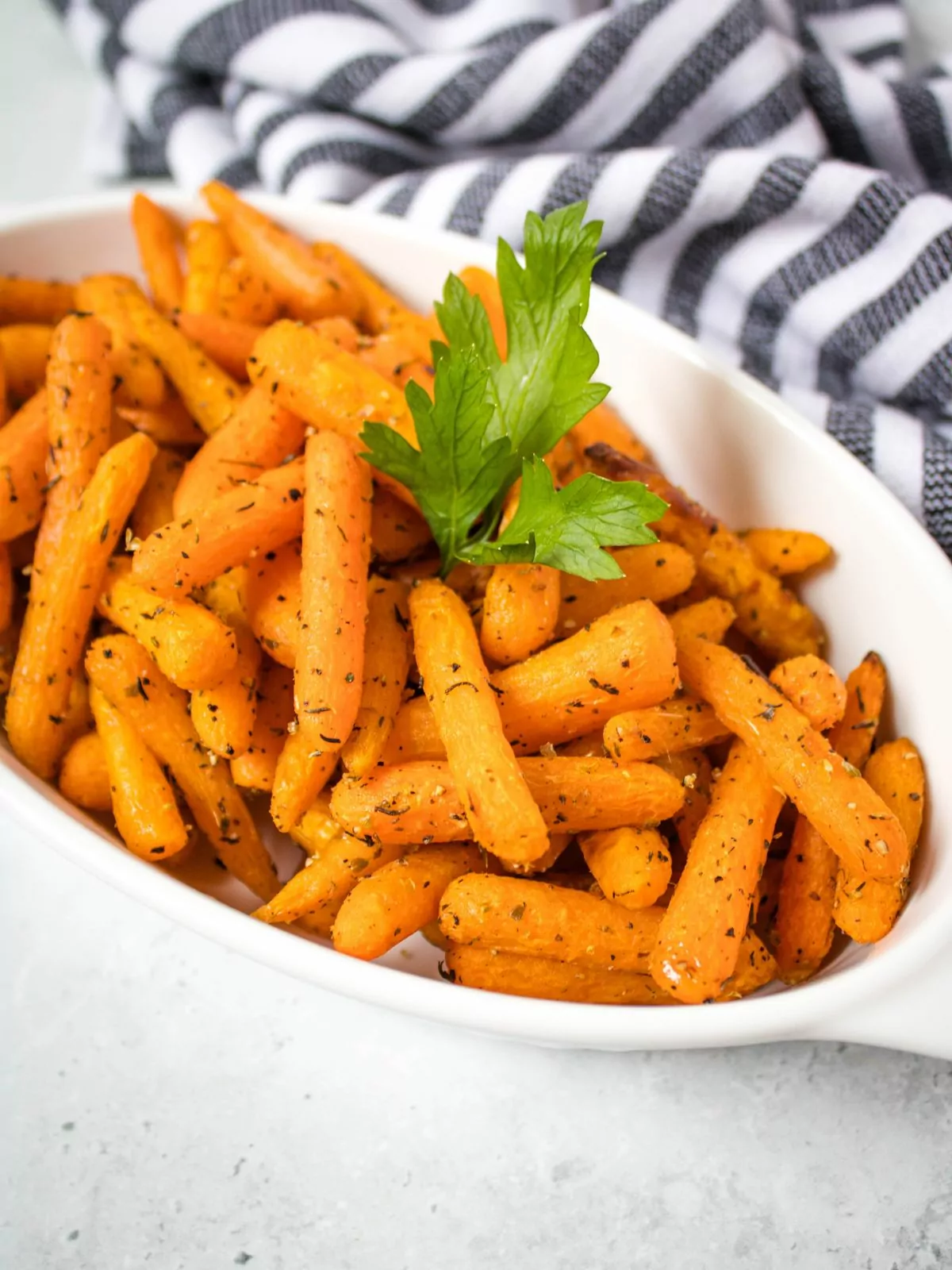 Air fried baby carrots in an oval white serving dish