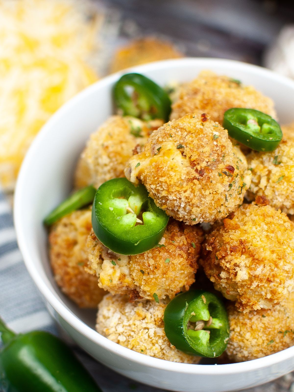 Bowl of air fried jalapeno poppers with fresh jalapeno slices