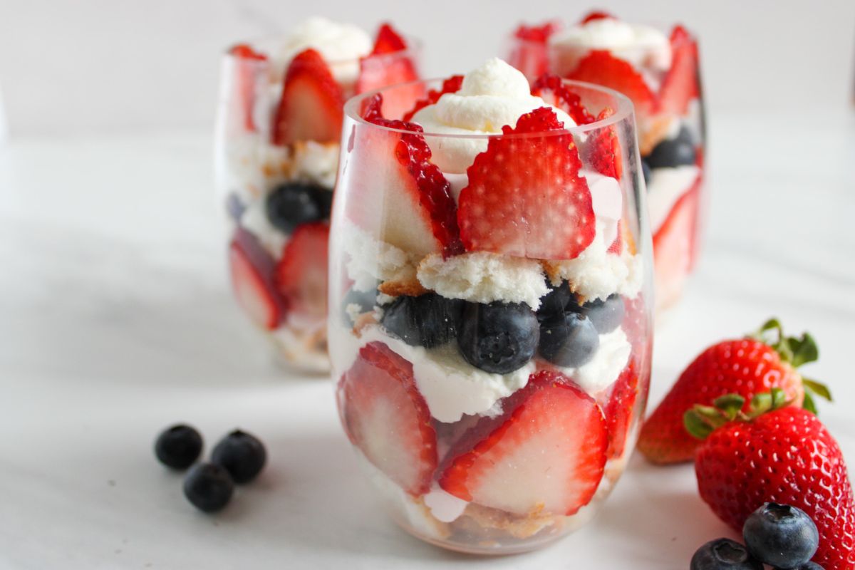 Fruit with whipped cream in tumbler glass.