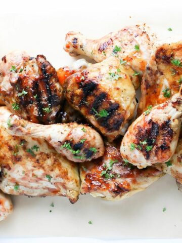 a plate of grilled barbecue chicken legs and thighs.