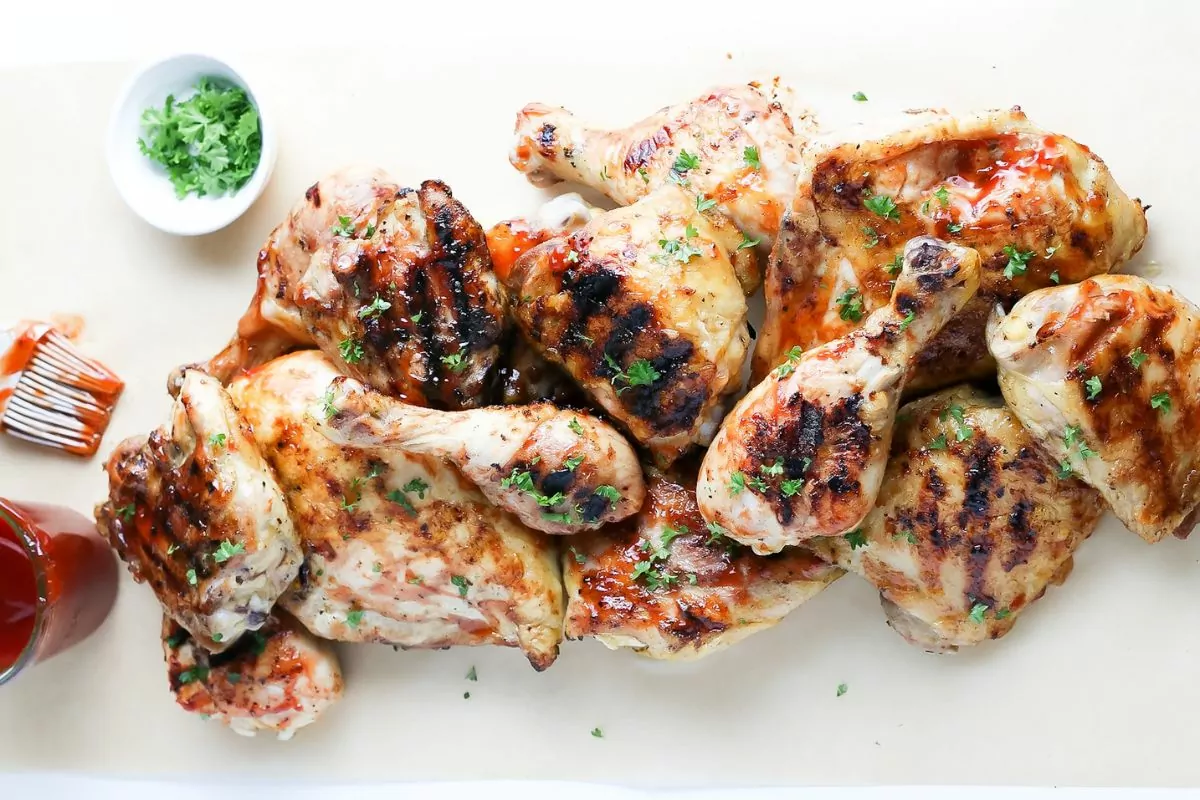 a plate of grilled barbecue chicken legs and thighs.