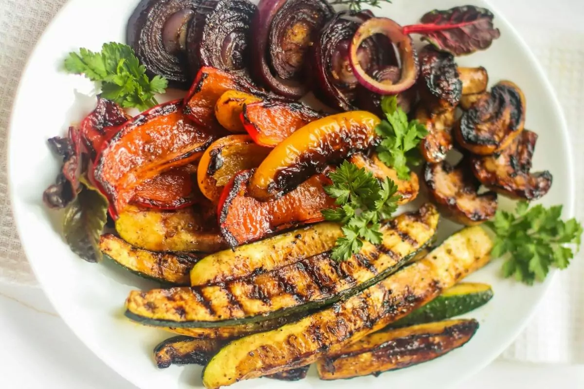 a plate of beautiful grilled veggies with fresh parsley as a garnish.