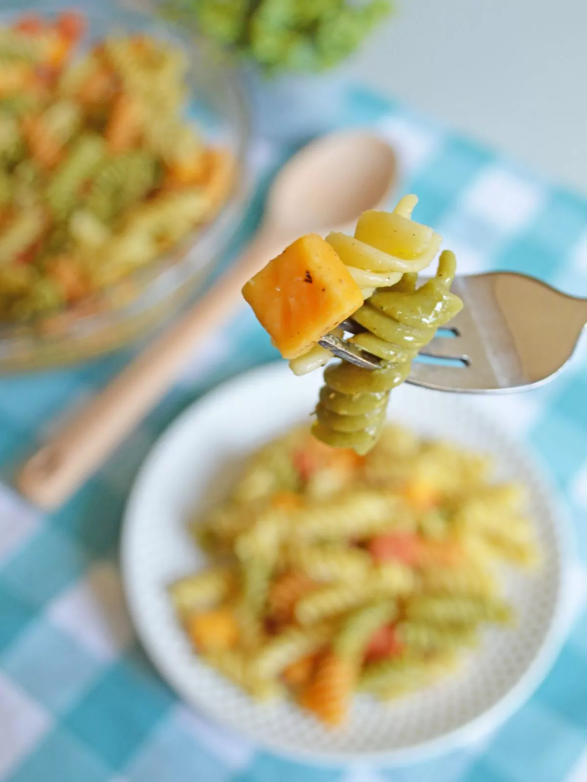 Bite of pasta and cheese cube on a fork