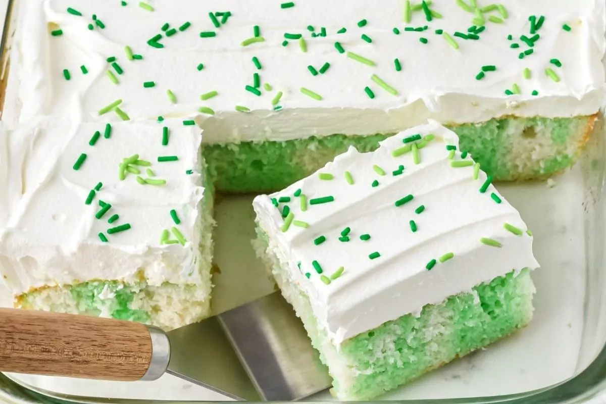a slice of white cake on a plate with ribbons of lime jello with cool whip topping.