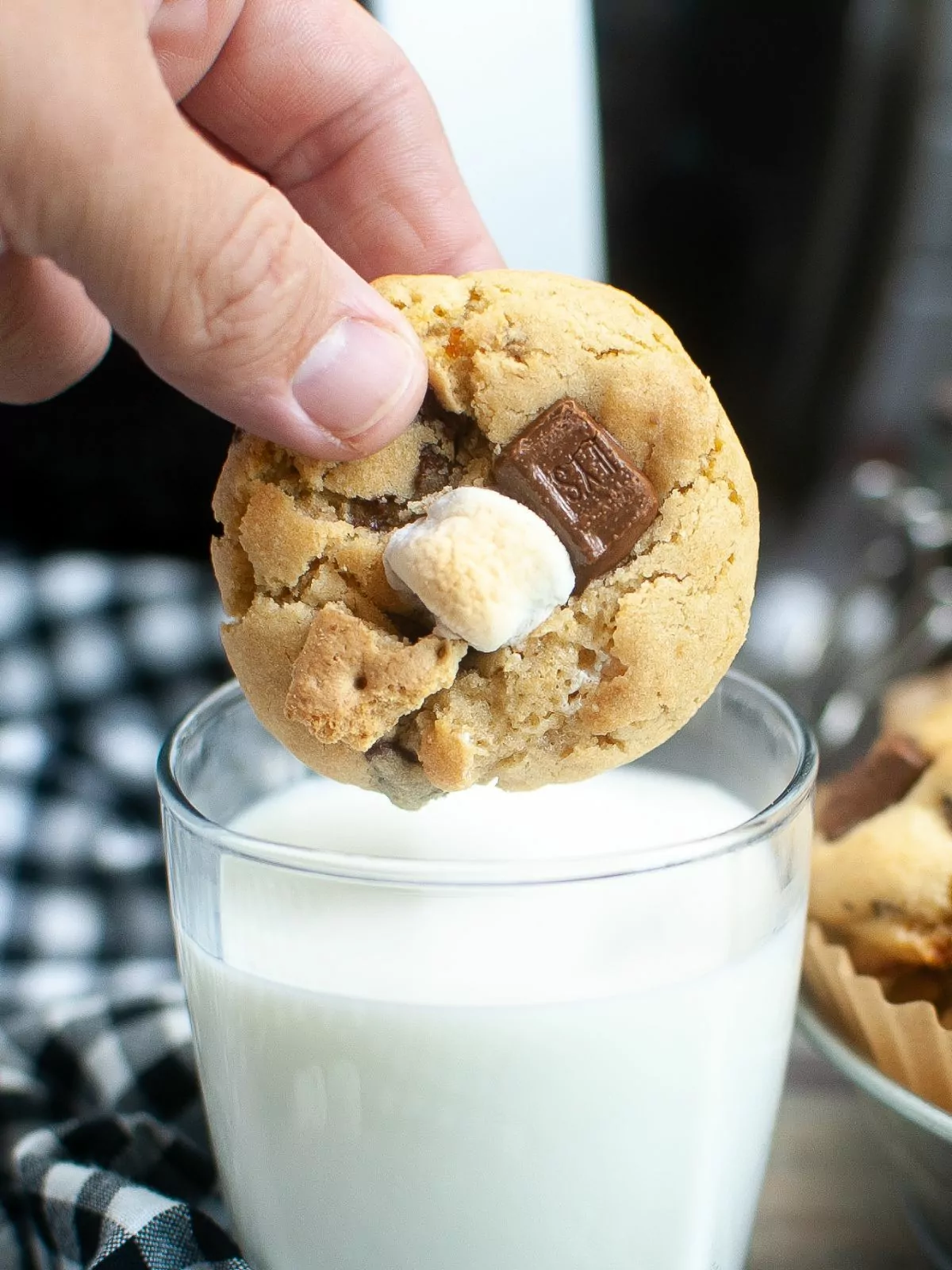 S'mores cookie about to be dunked in a glass of milk