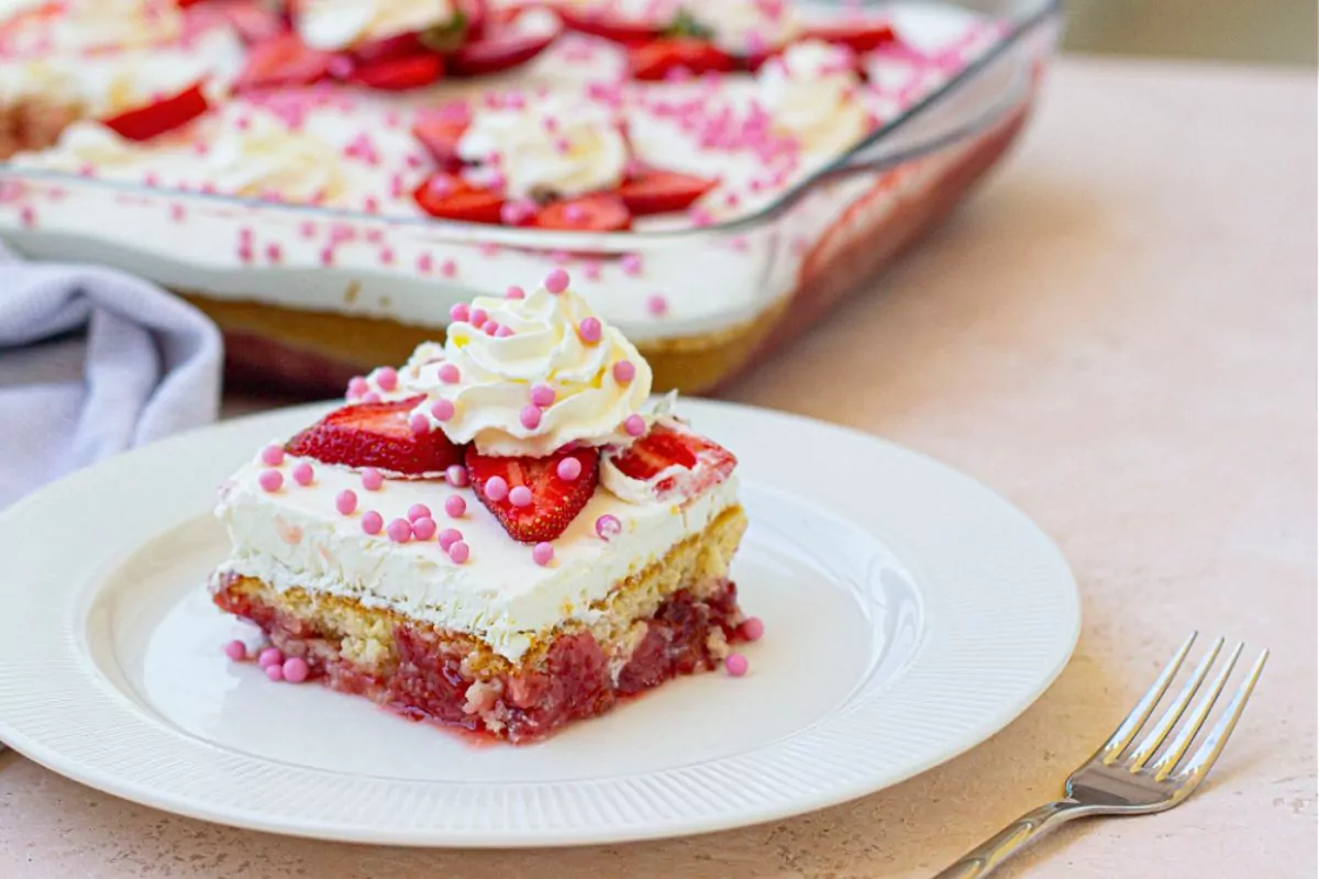 strawberry cake with frosting and sliced strawberries.