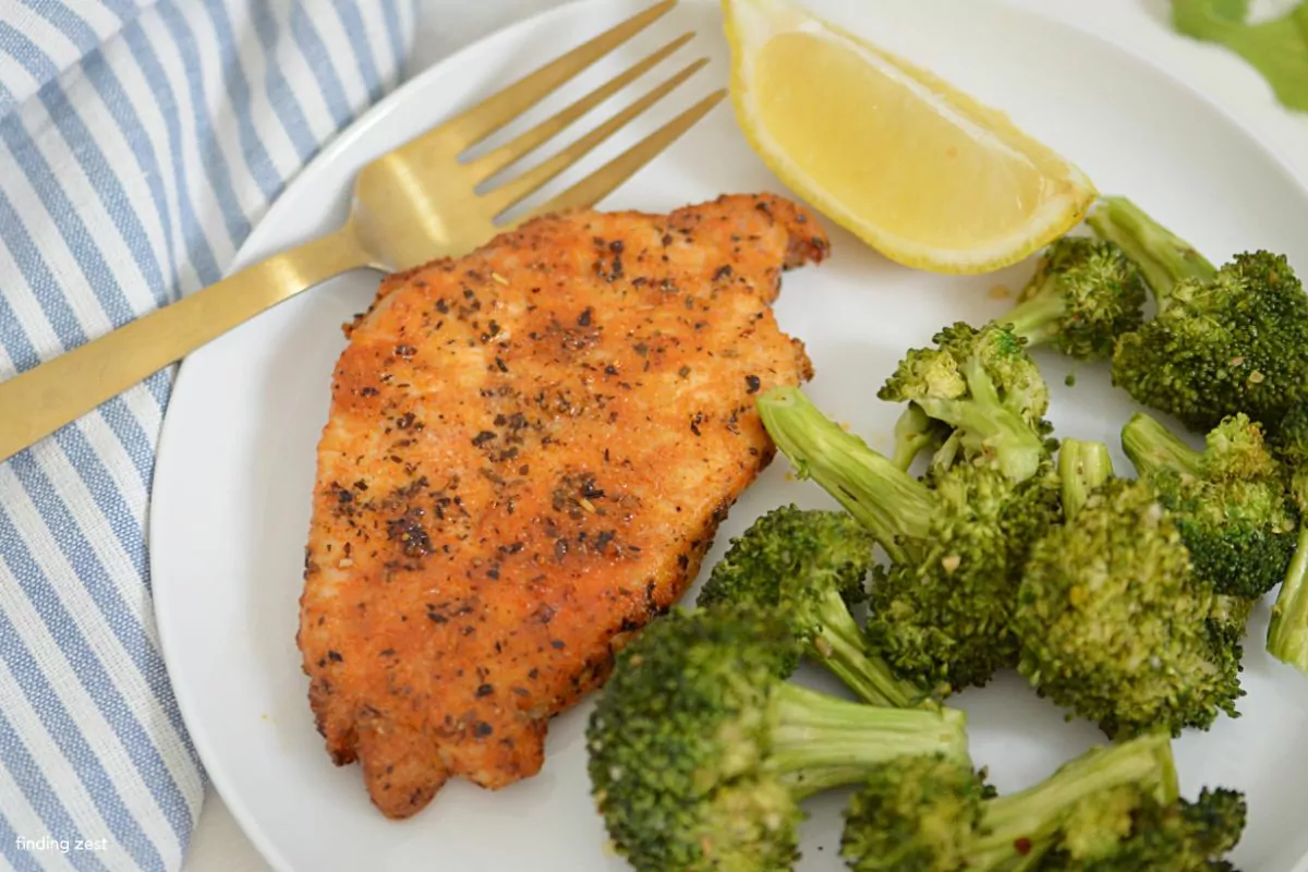 a plate of broccoli with thin air fryer pork chops.