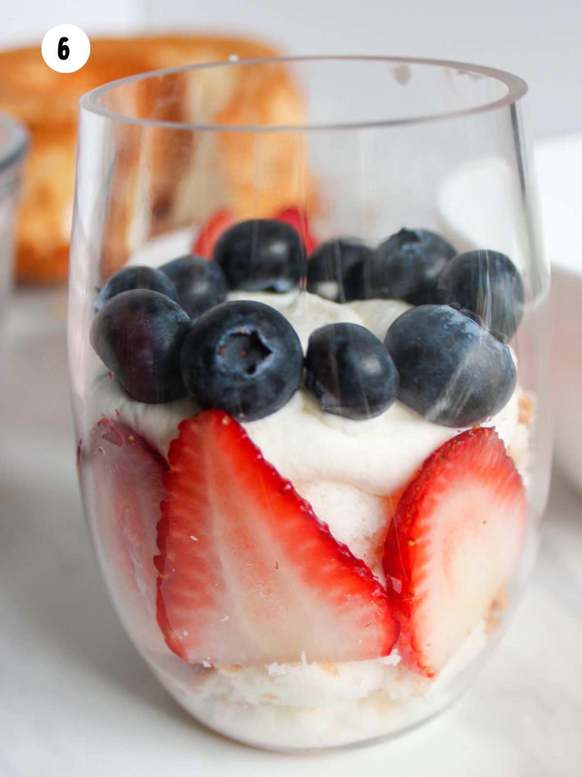 blueberries on top of whipped cream and strawberries.