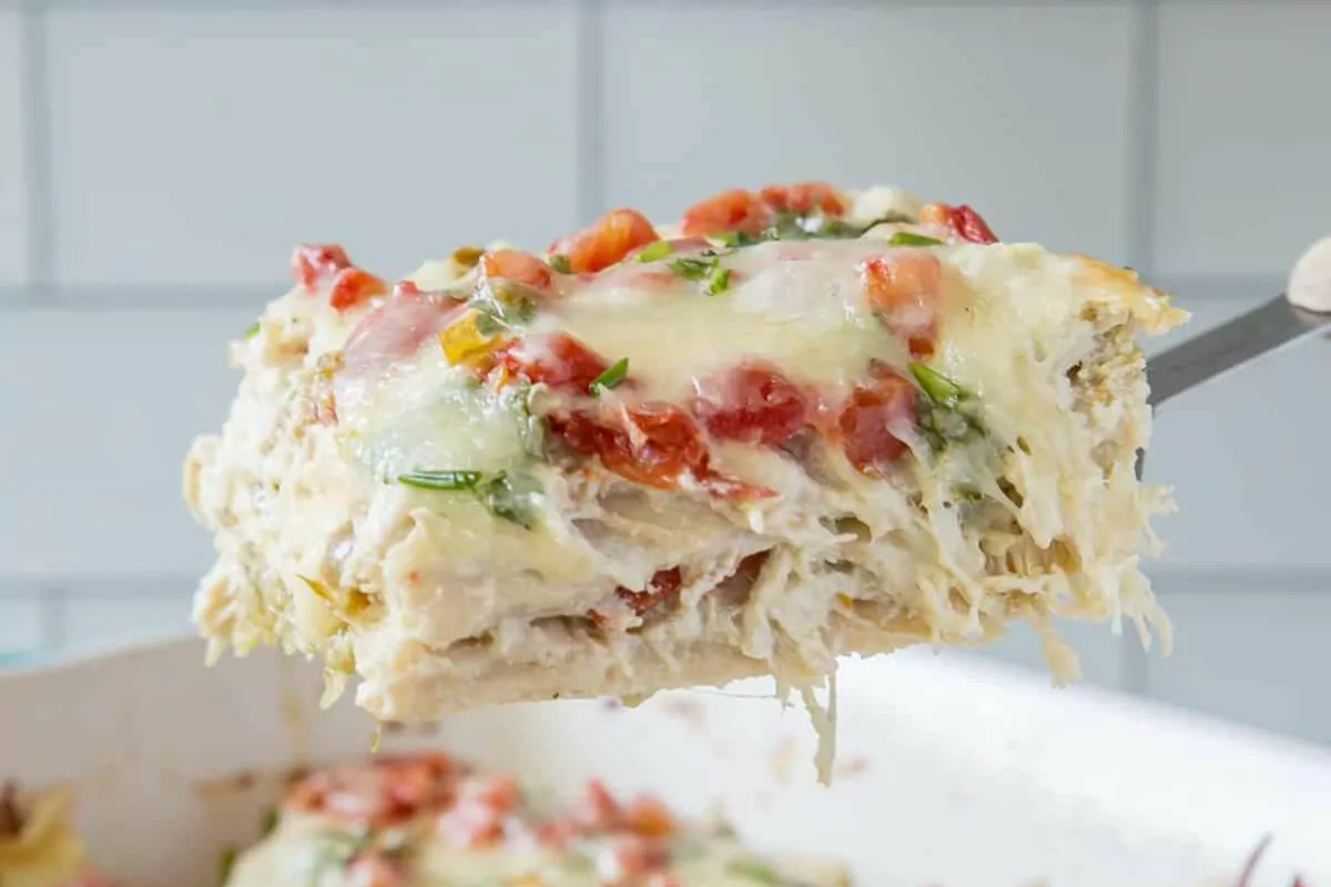 a serving of tortilla and chicken casserole being lifted by a spatula.