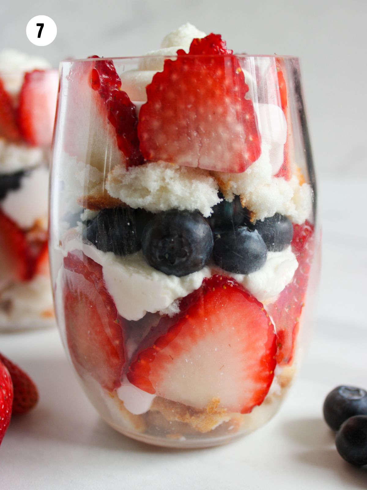 glass filled with angel food cake, berries and whipped cream.