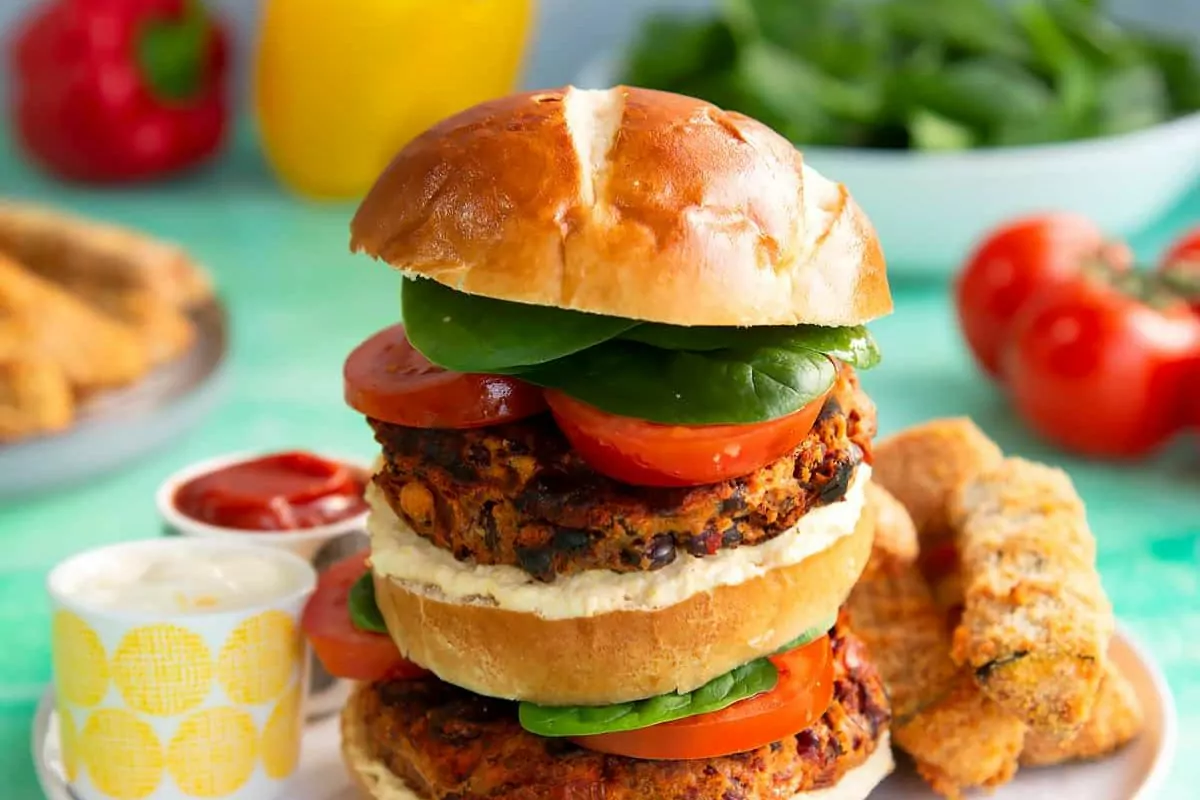 Burgers on buns with lettuce and tomato slices.