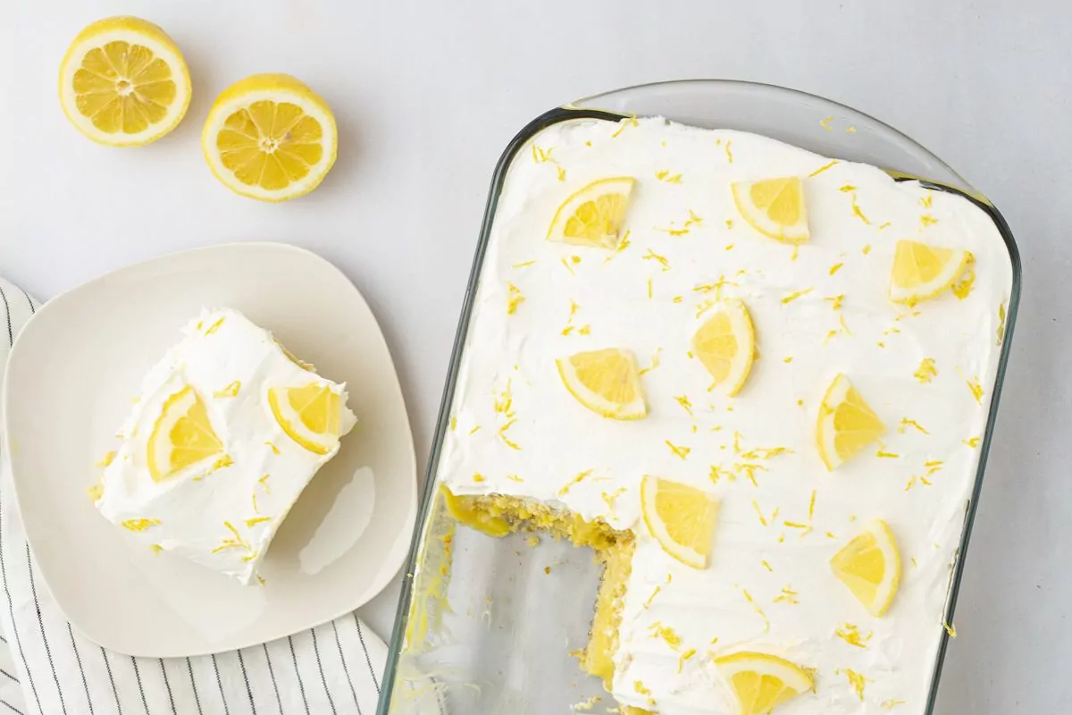 a cake with cool whip topping and lemon slices.