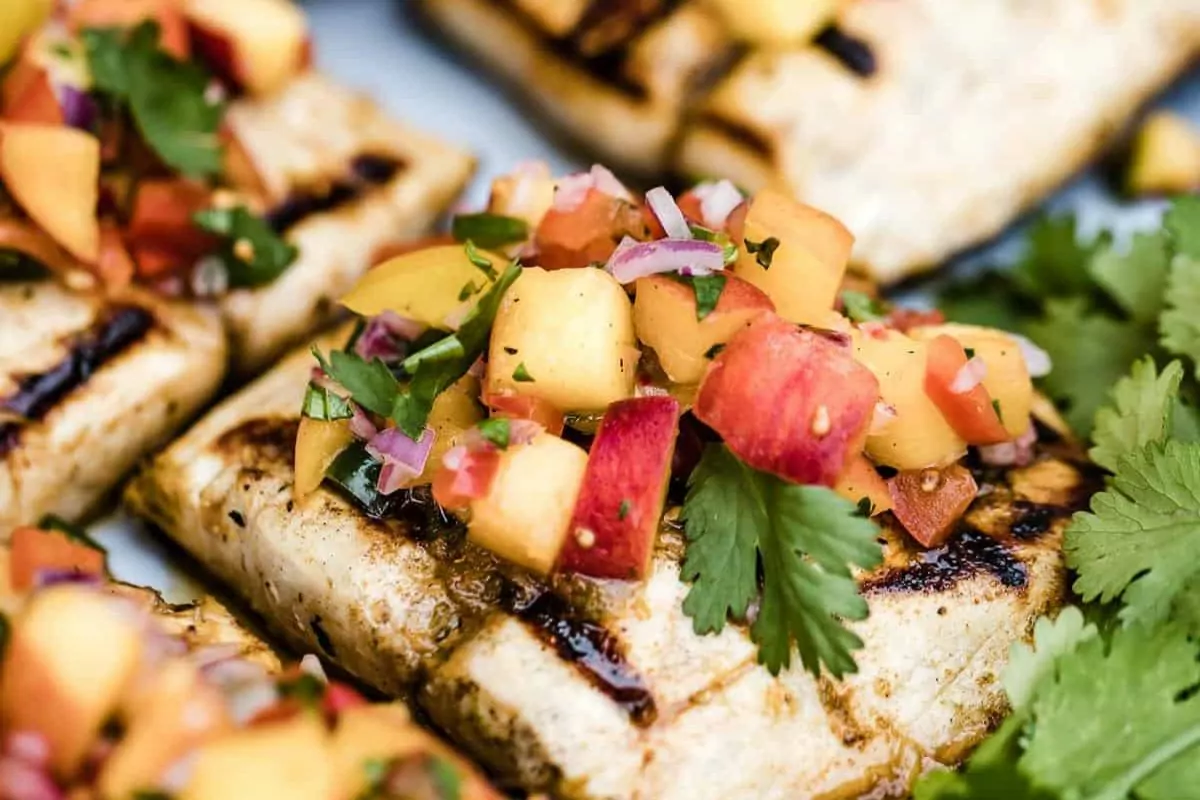 Grilled fish with peach salsa over top