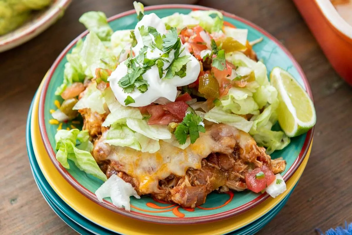 a serving of easy chicken tortilla casserole with lettuce and sour cream over the top.