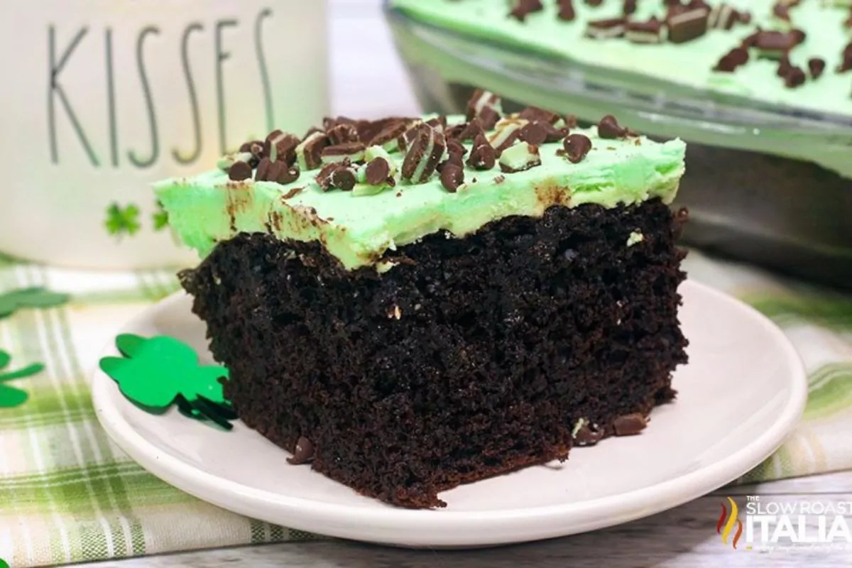 A slice of chocolate cake with pudding, andes mints and hot fudge sauce.