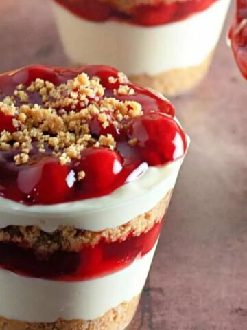 cheesecake pudding with cherry pie filling in cups.