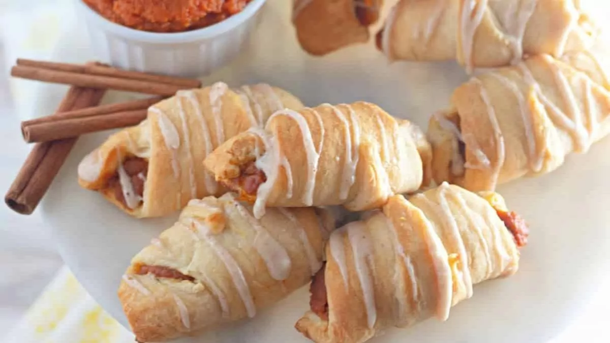 A plate of pumpkin croissants with pumpkin filling visible on the ends.