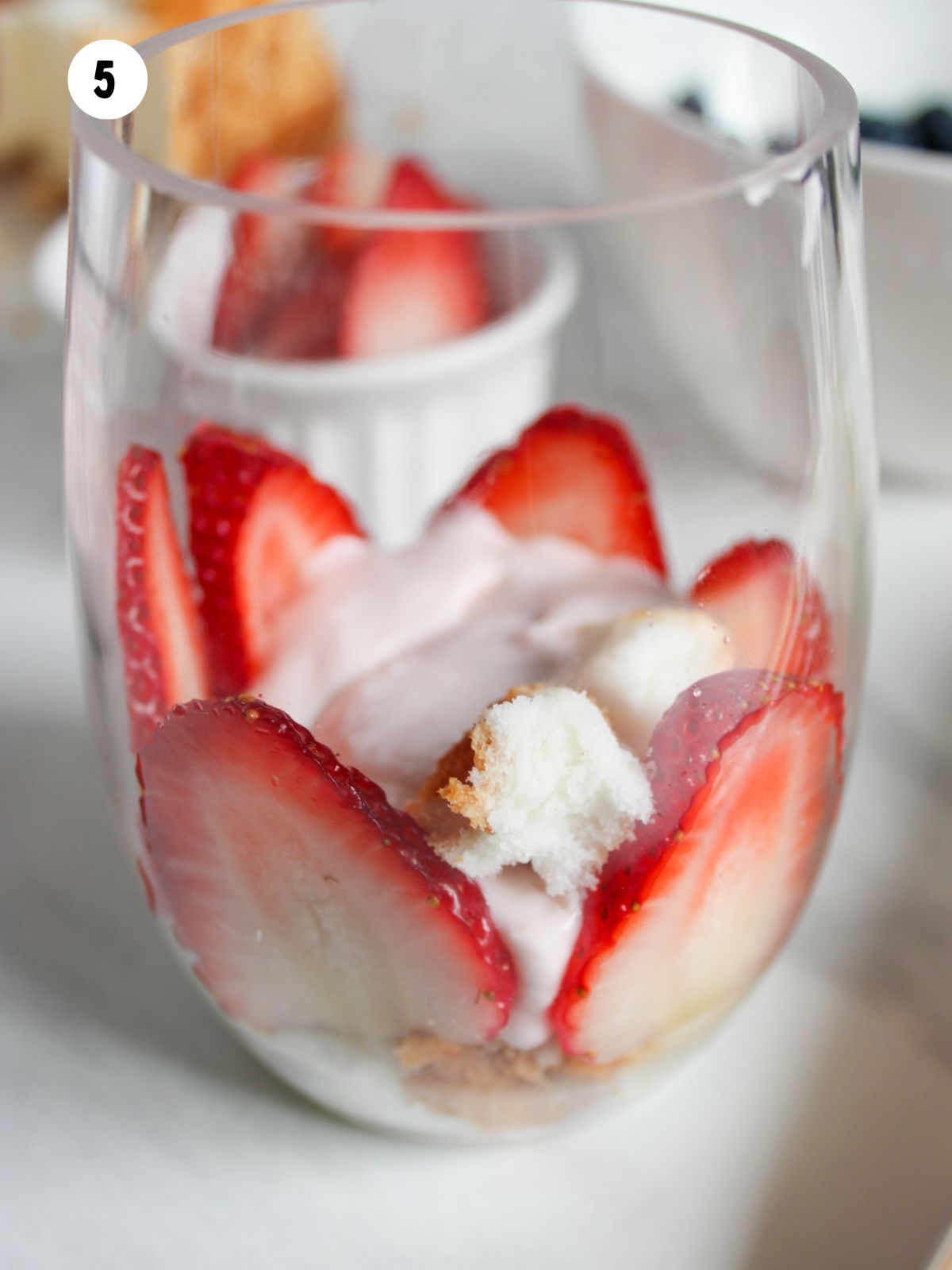strawberries and angel food cake in a clear glass.