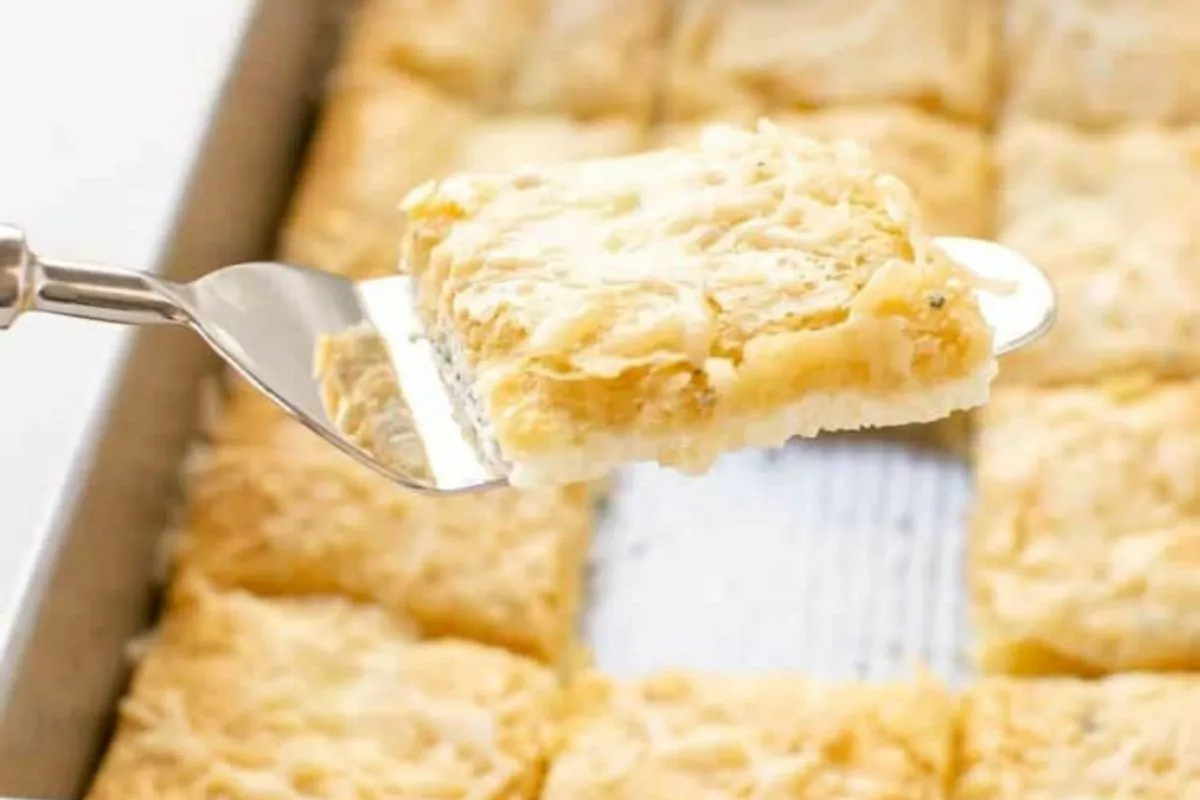 a slice of cheesy garlic pizza on a spatula, ready to serve.