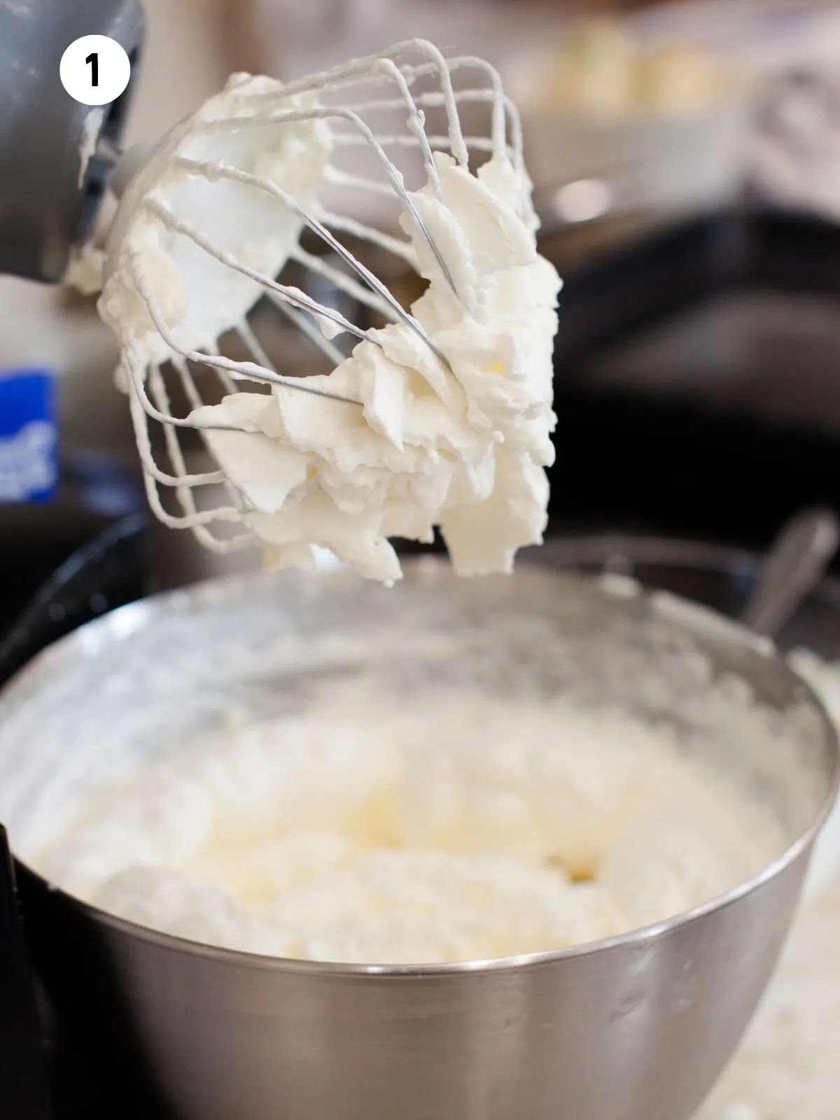 homemade whipped cream in bowl with wire whisk beaters.