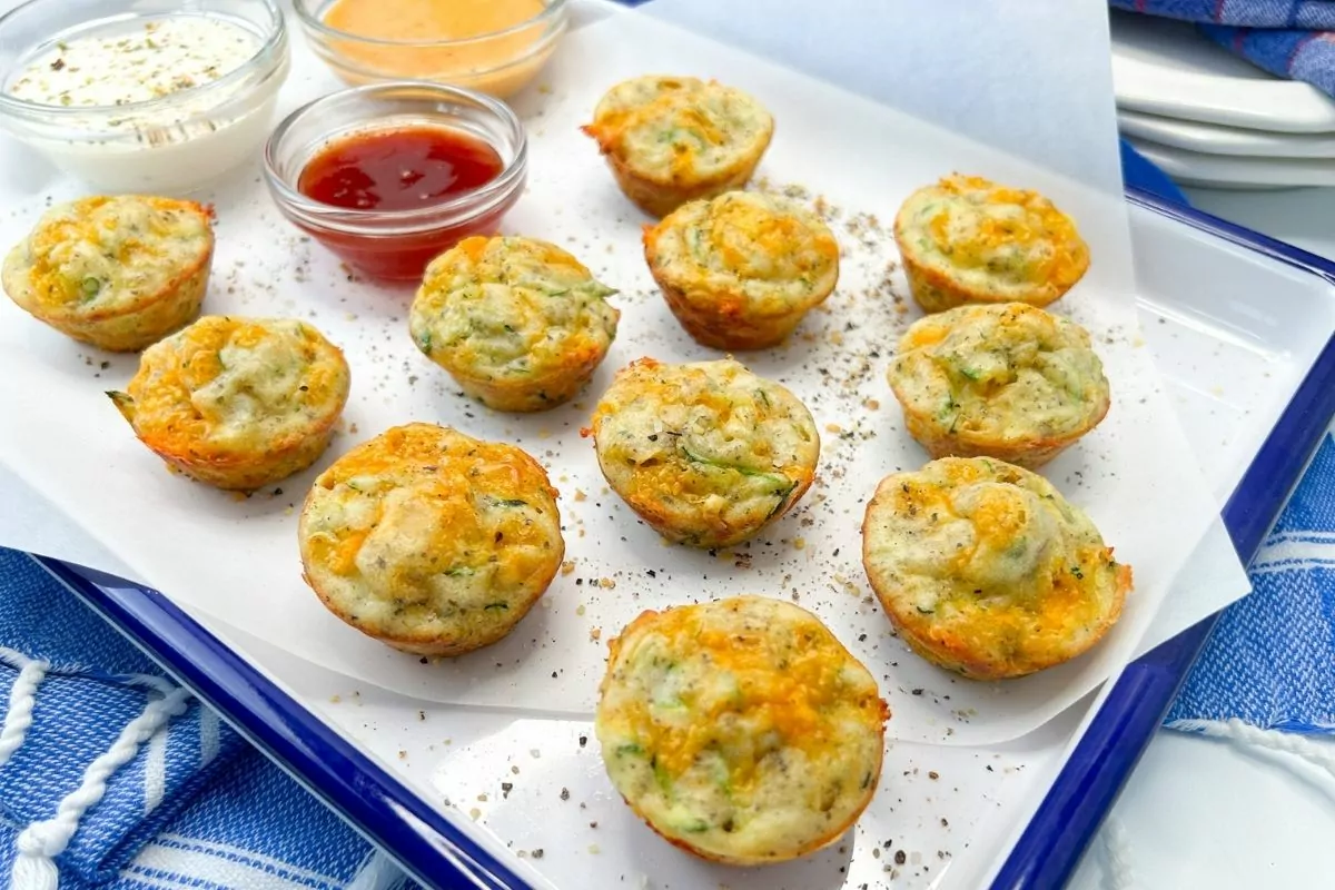 mini zucchini puffs on tray with sauces.