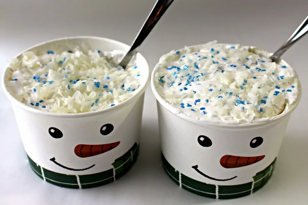 two snowman cups with coconut and blue sprinkle toppings