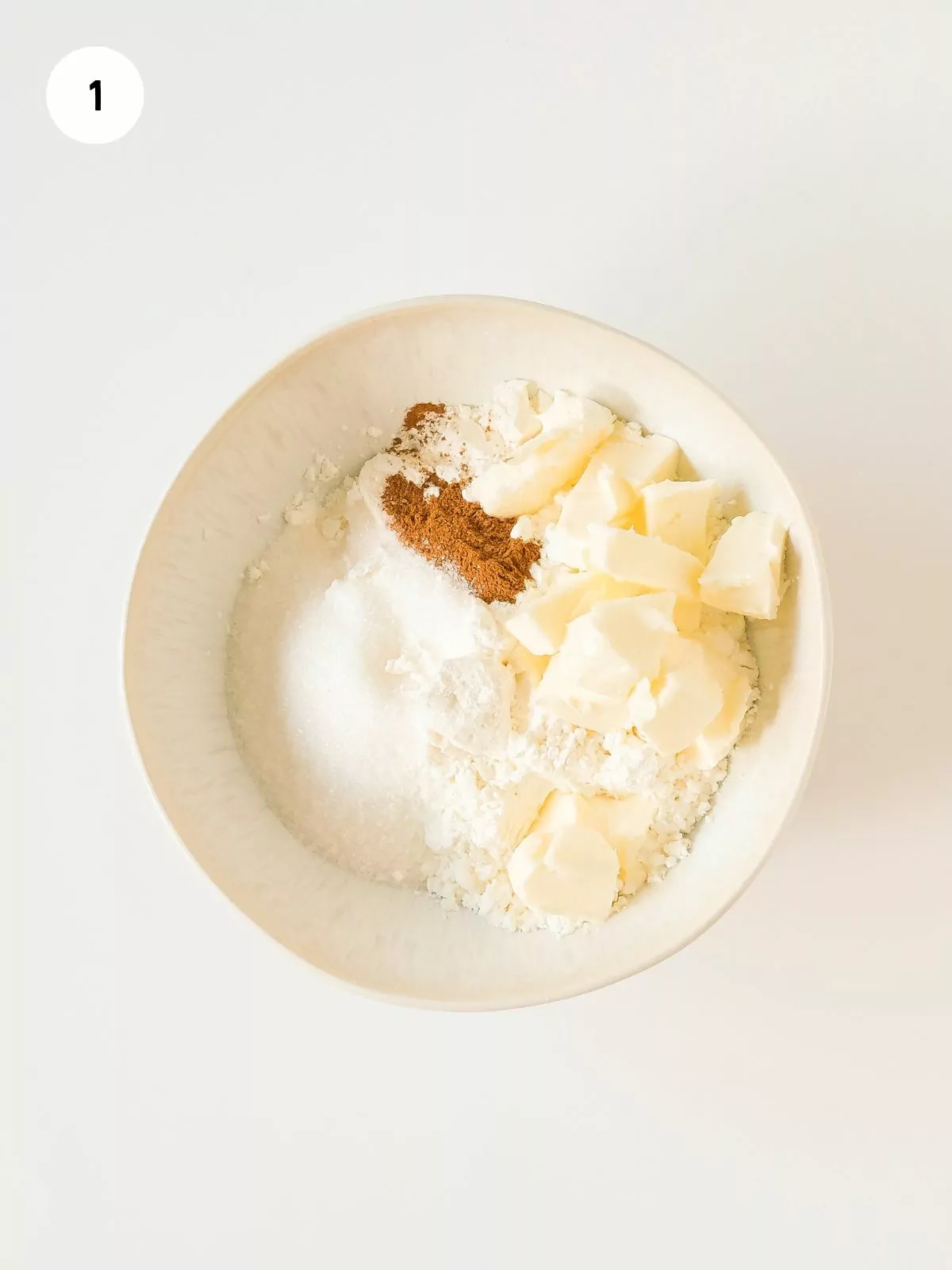 flour, sugar, cinnamon and butter in mixing bowl