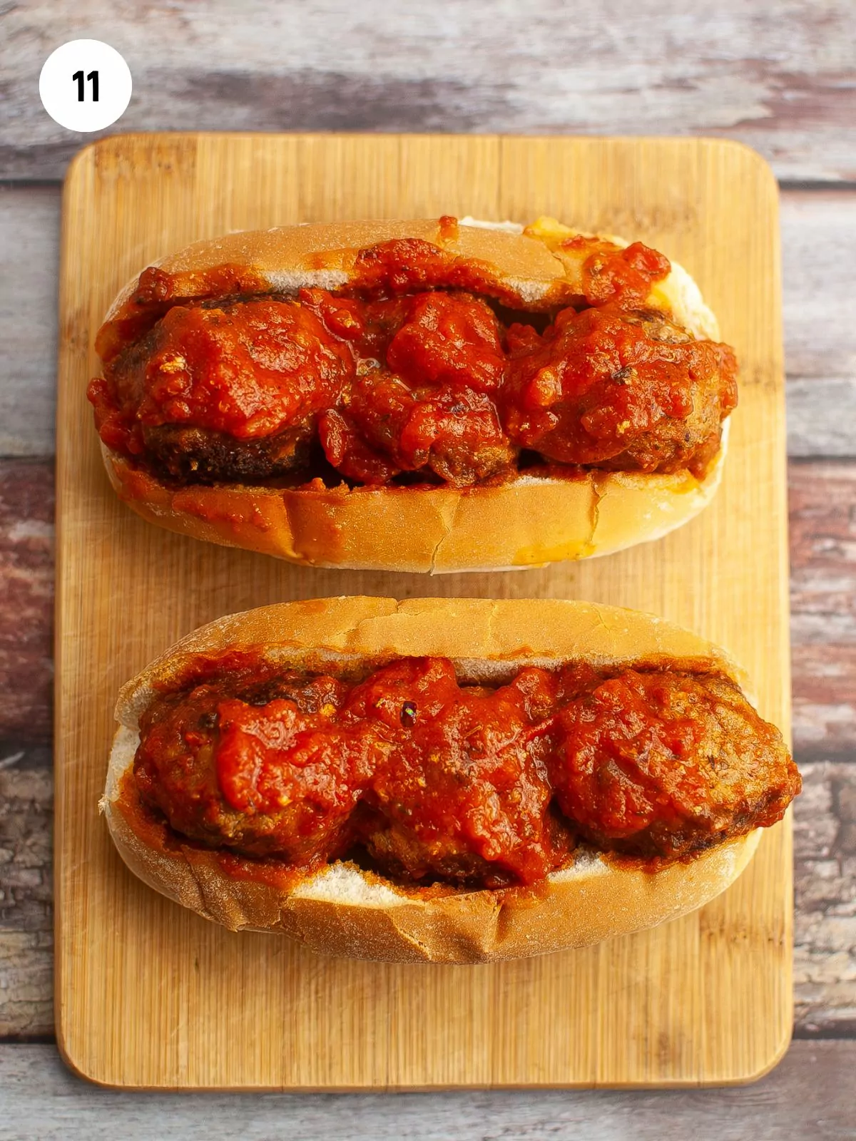 meatballs in hotdog buns on a wooden cutting board