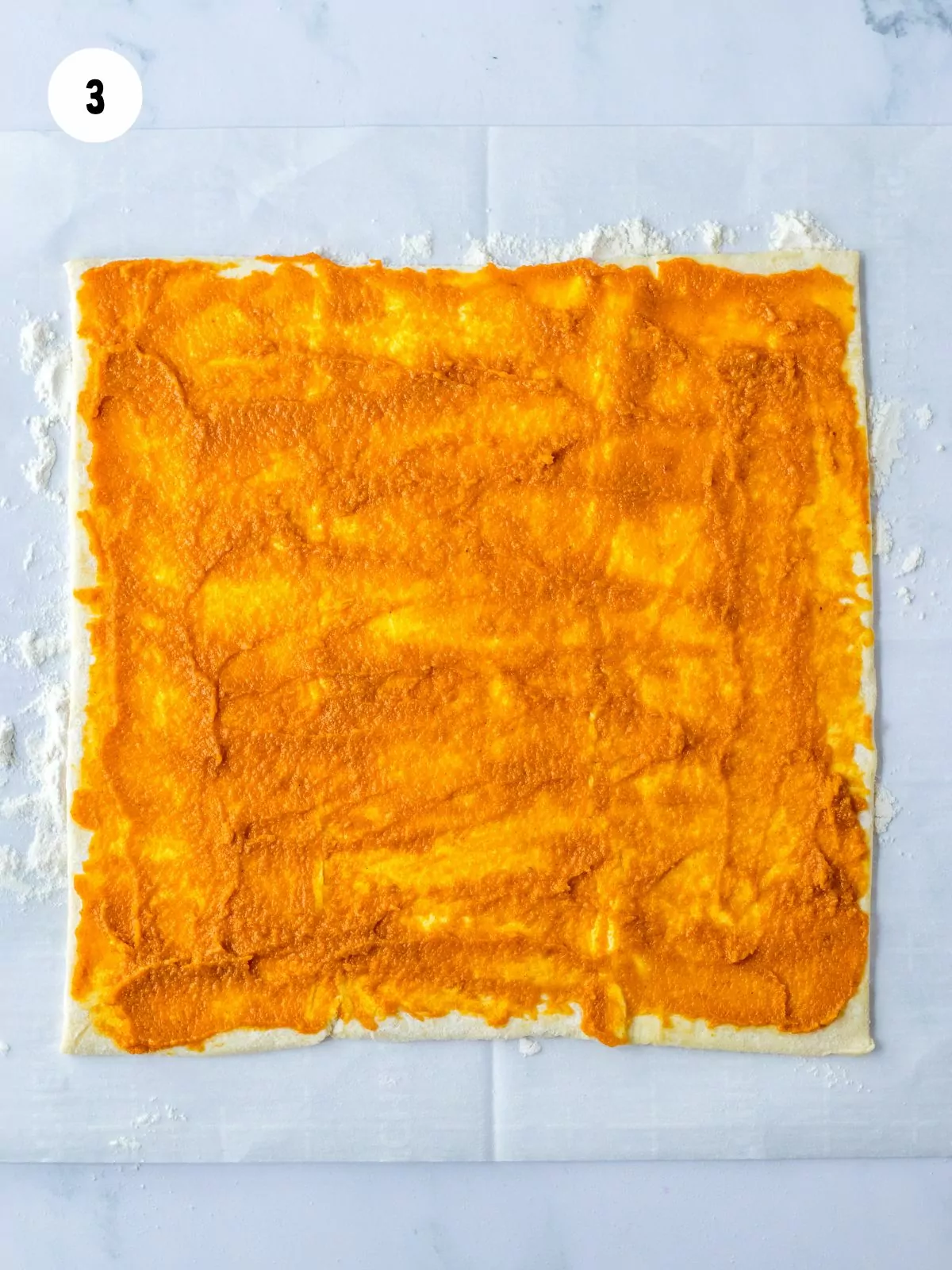 pumpkin filling spread on top of the puff pastry sheet