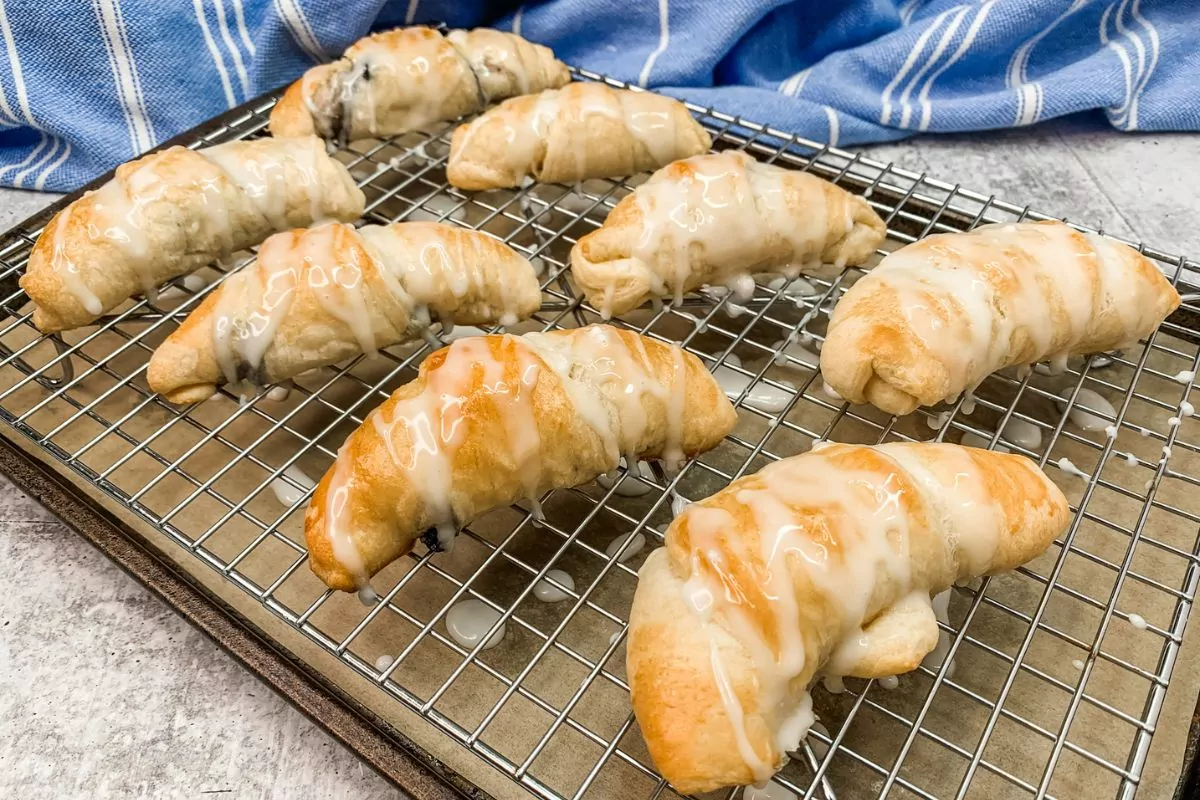 crescent rolls baked and filled with blueberries and cream cheese on cooling rack.