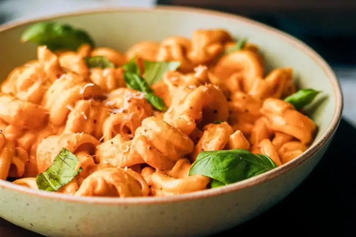 a bowl of ricotta pasta with spinach and tomato