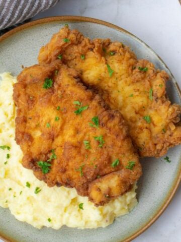 chicken with mashed potatoes on plate.