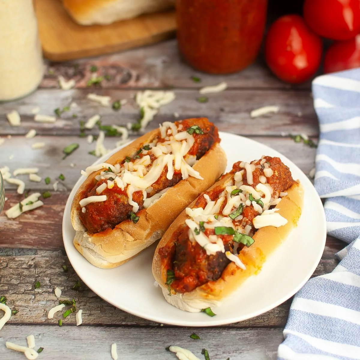 2 meatball sandwiches served on a white plate.