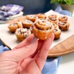 hand holding mini cinnamon rolls.