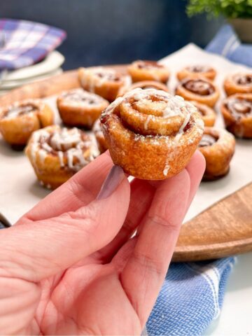 hand holding mini cinnamon rolls.