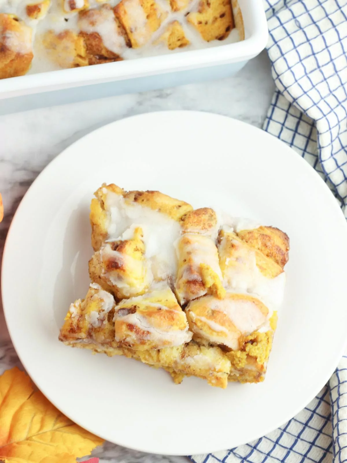 top view of slice of Pumpkin Cinnamon Roll Casserole on a white plate