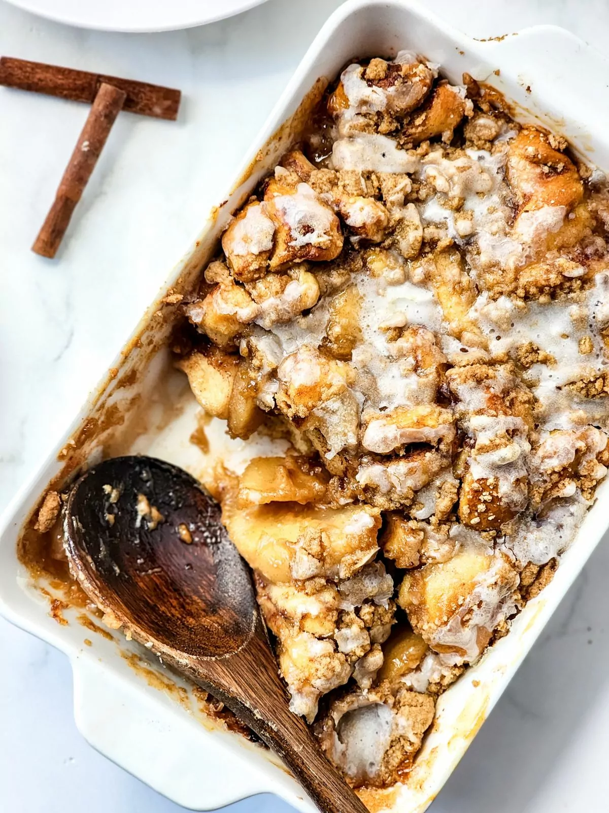 Cinnamon Roll Casserole with a wooden spoon