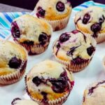 a tray of blueberry muffins in wrappers.
