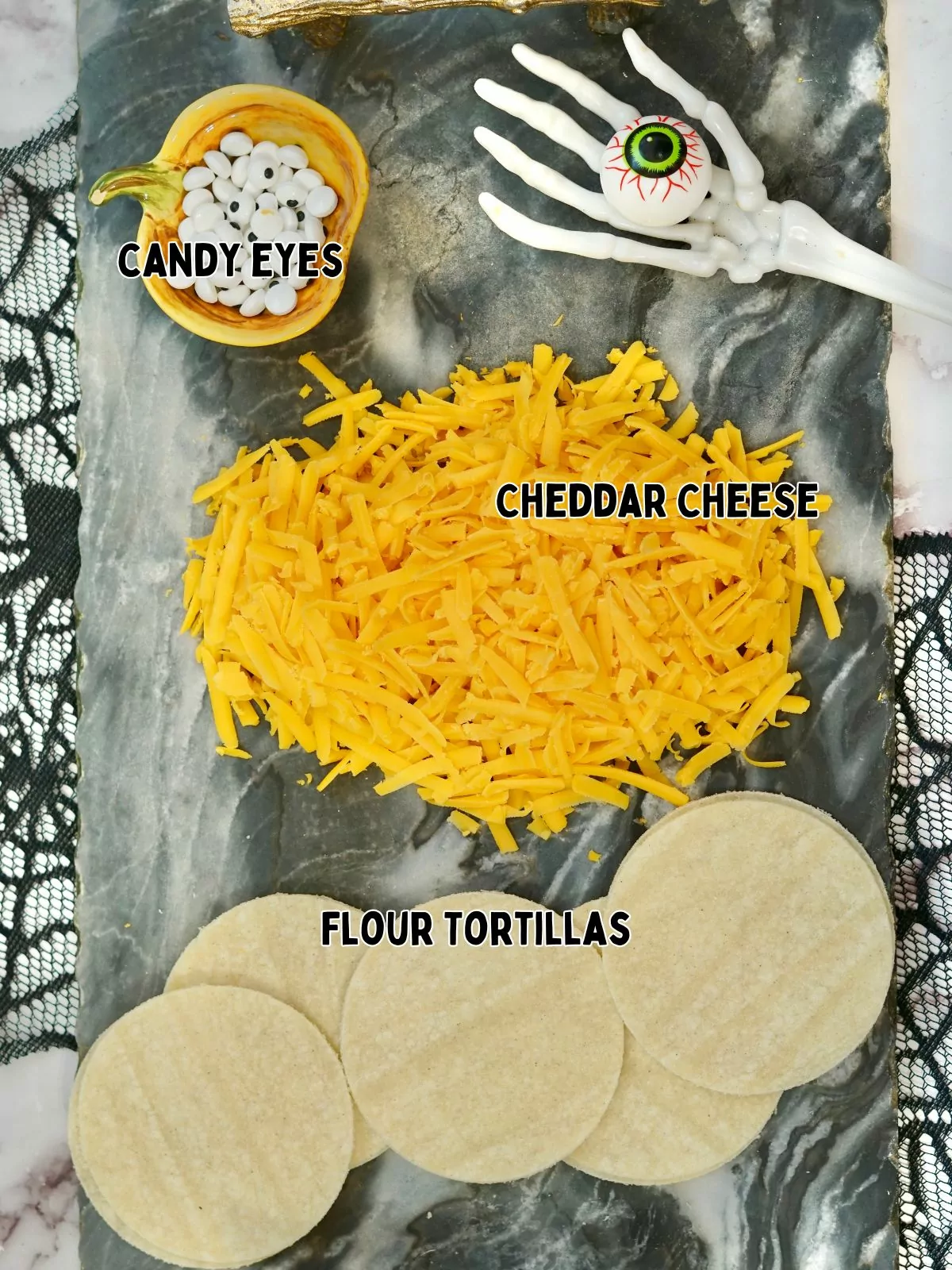 ingredients for Halloween sandwich with grated cheese, flour tortillas and candy eyes.