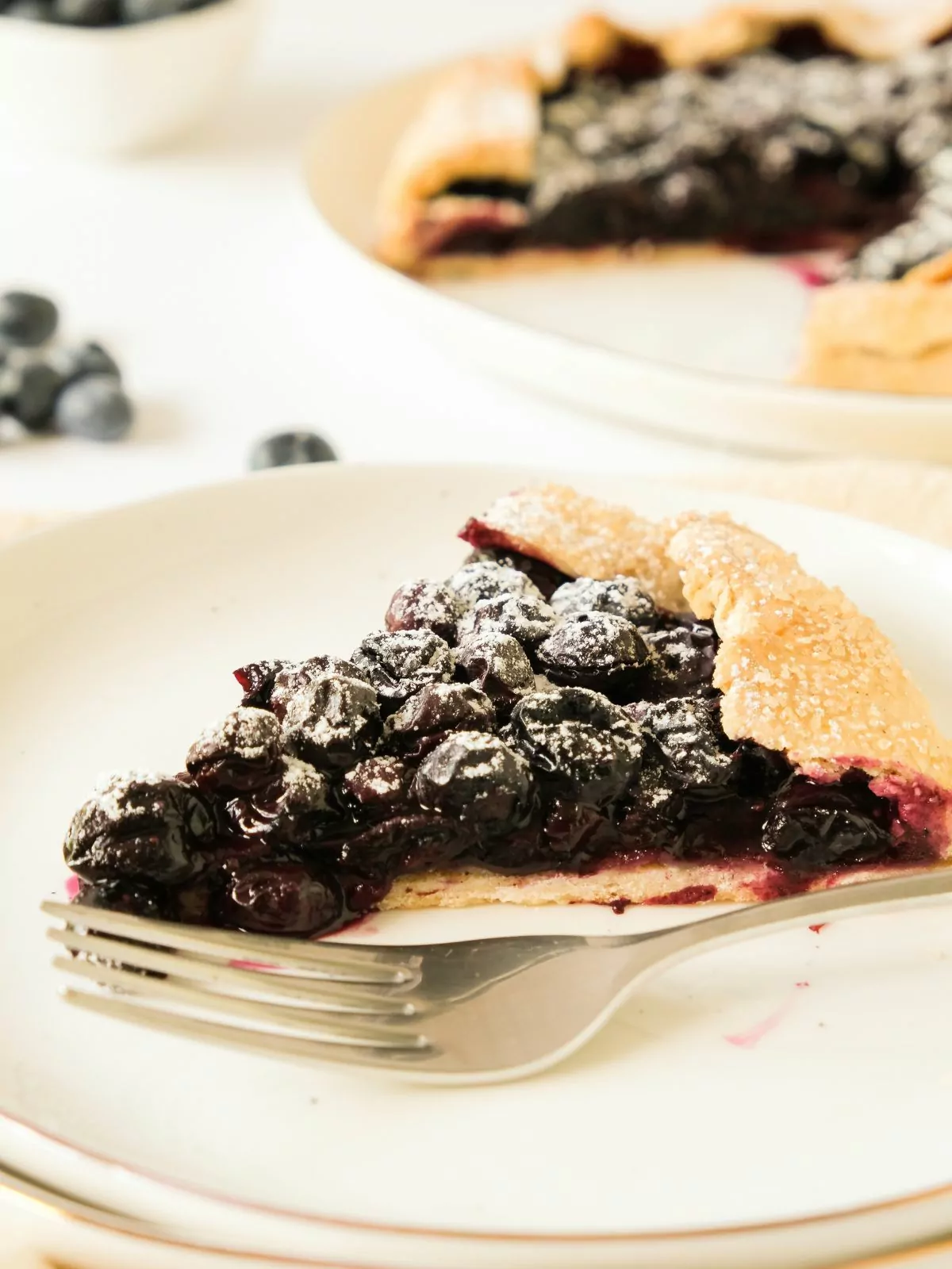 slice of Blueberry Galette on a white plate with a fork