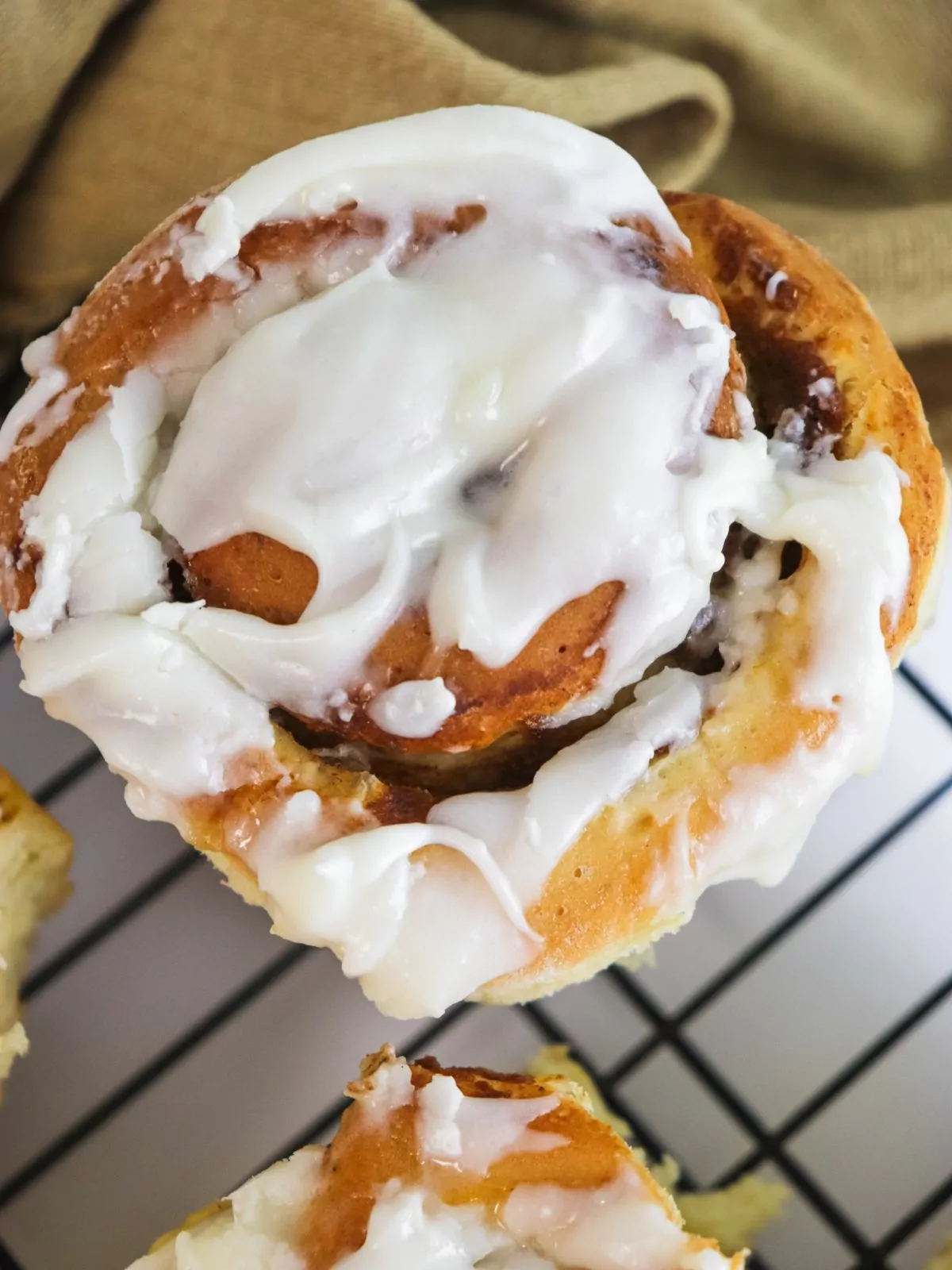 close up of frosted pumpkin cinnamon roll