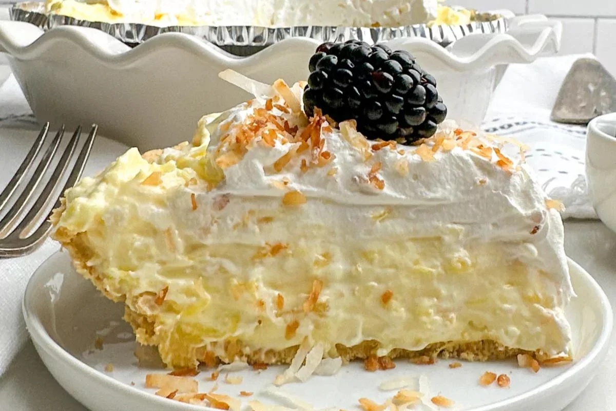 a plate of cream cheese cake pie with raspberry on top