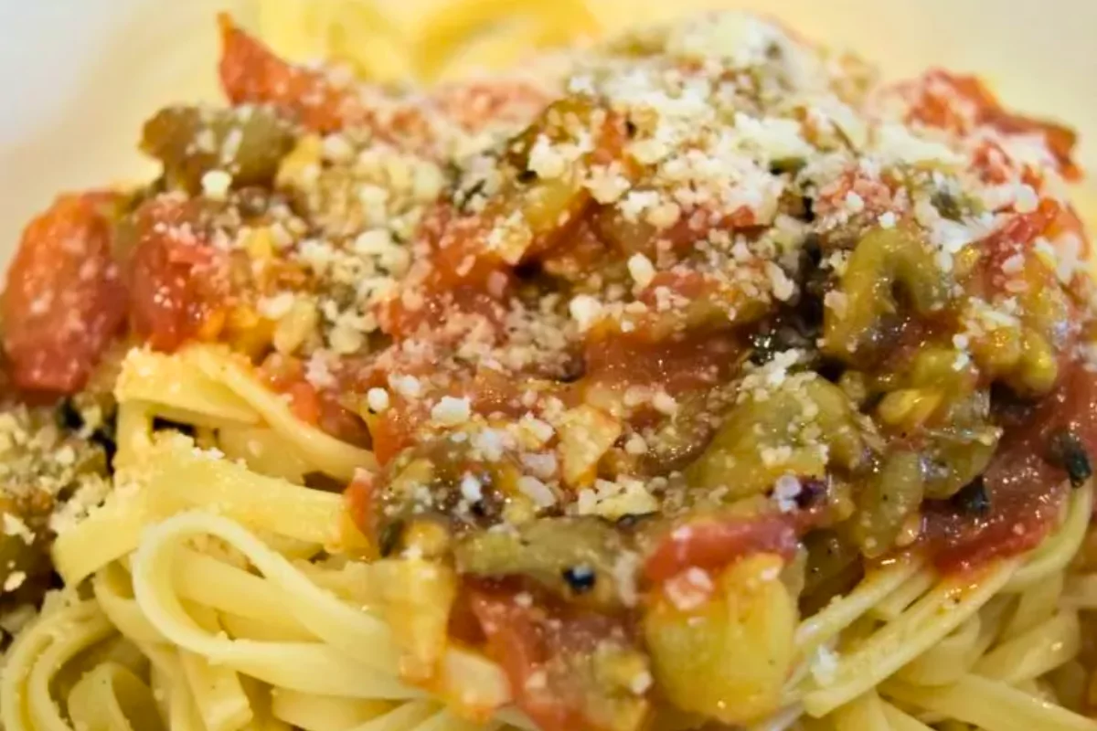 a plate of pasta with sauce and cheese toppings