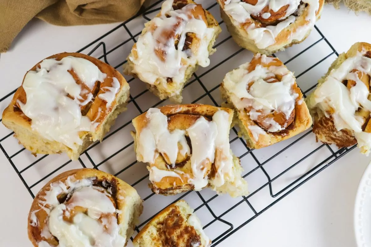 frosted Pumpkin Cinnamon Rolls on a wire cooling rack