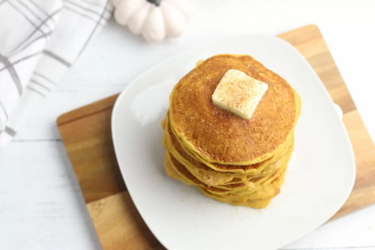 stack of pumpkin pancakes with a pat of butter on top.