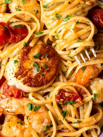 a plate of pasta with shrimp and tomato