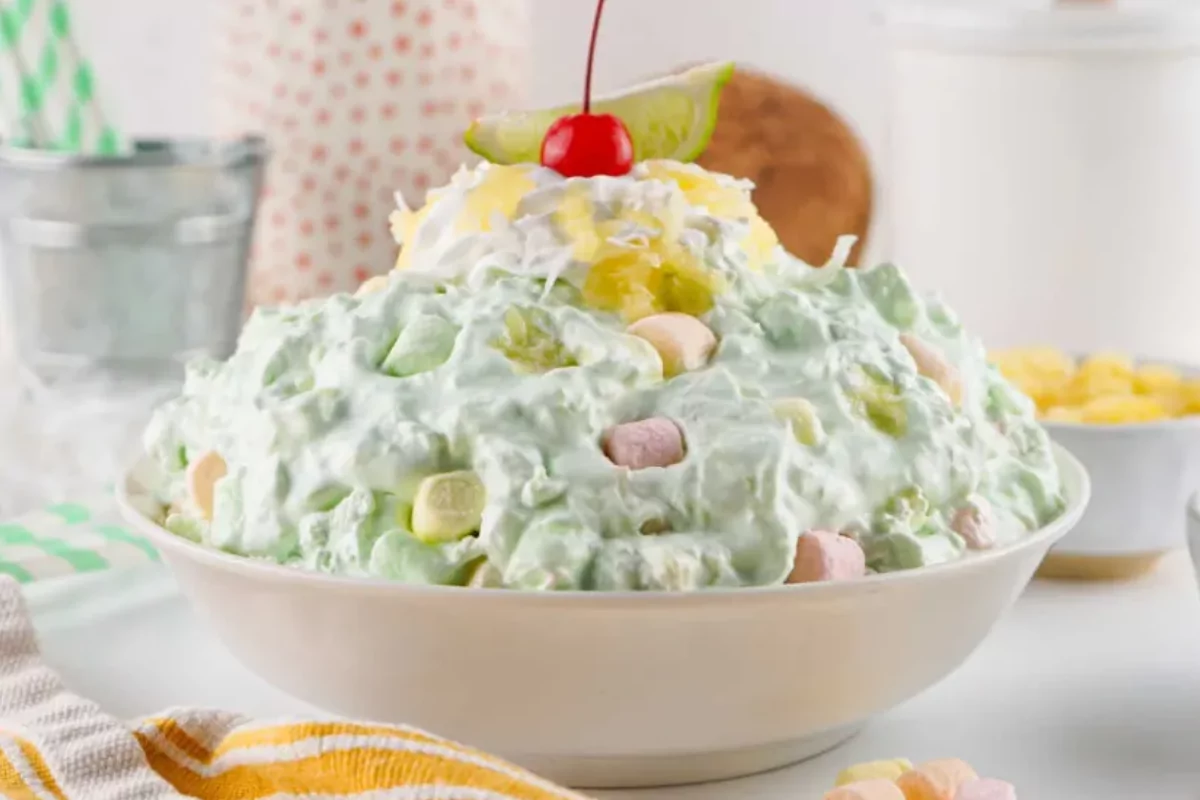 a bowl of seafoam salad with cherry and lemon on top