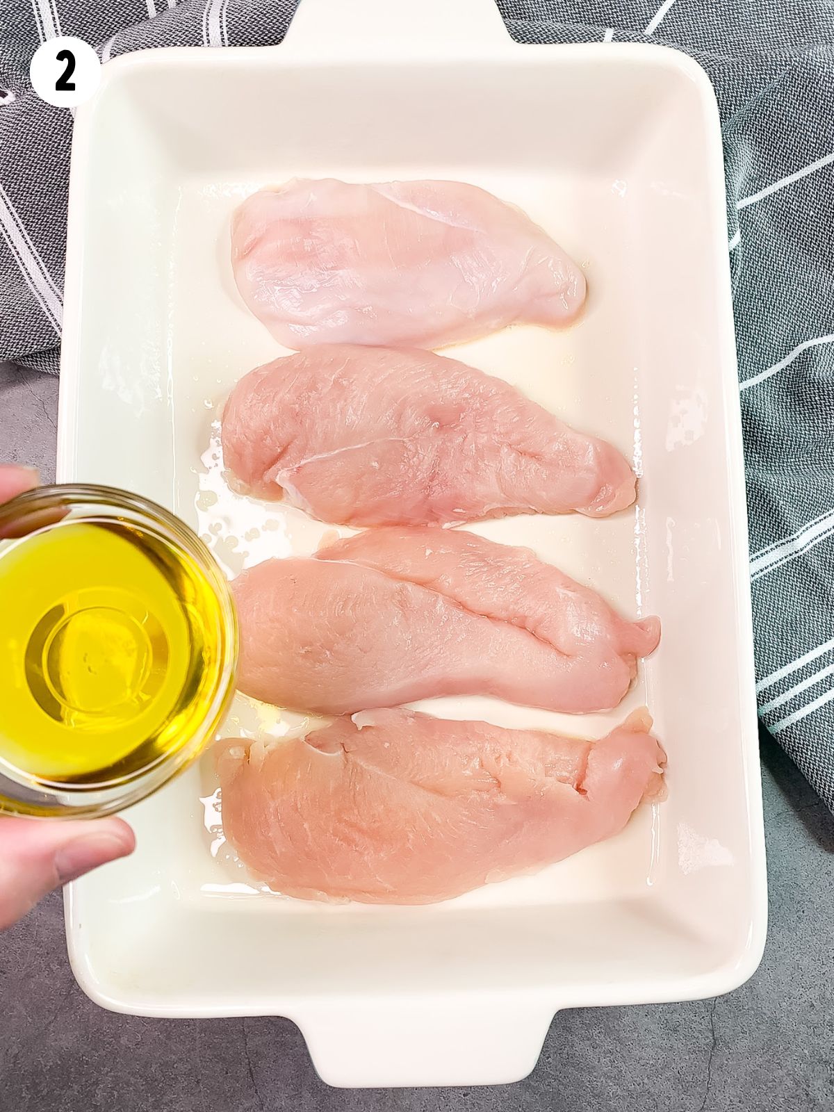 add olive oil to chicken in baking dish.