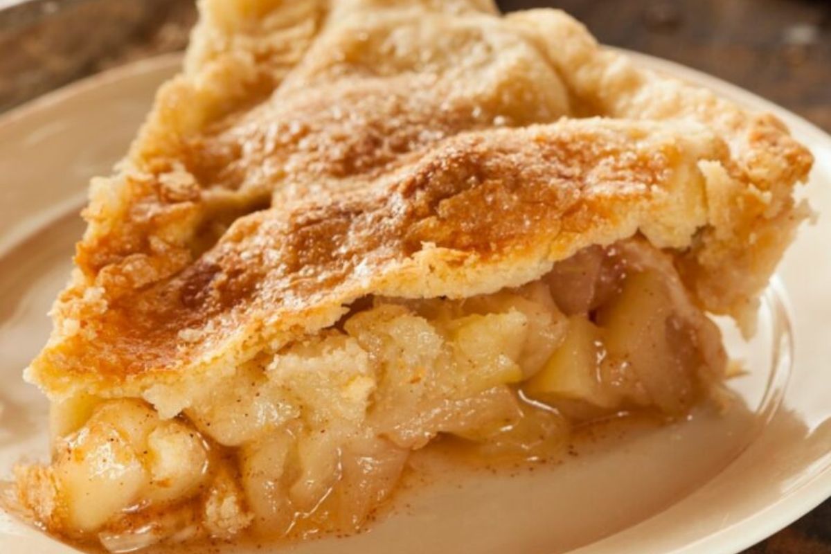 a slice of apple pie on a white plate.